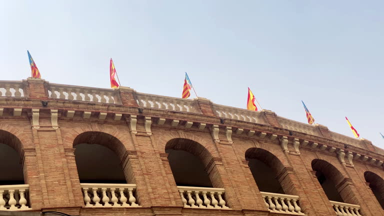 Spanish and Valencian flags waving on top of bullring