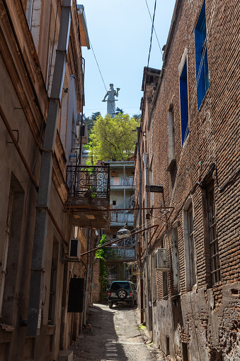 Tbilisi, Georgia - May 03, 2019: Old Tbilisi street view with Kartlis Deda monument on the background, vertical photo
