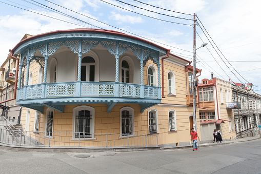 Tbilisi, Georgia - May 3, 2019: Tbilisi street view with people walking near old residential houses with balconies