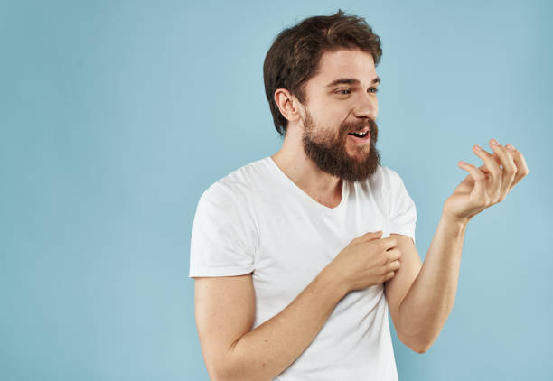 istock An energetic man gesturing with his hands on a blue background and a thick beard in a white t-shirt 2149811808