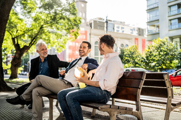 Coworkers talking on a bench in the city square