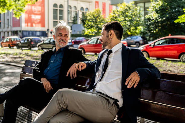 istock Coworkers talking on a bench in the city square 2149812830