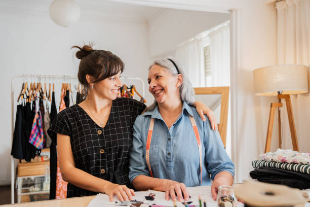 Seamstresses talking embracing on an atelier
