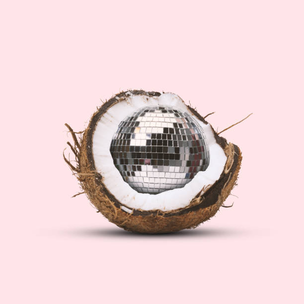 Contemporary art collage. Coconut with disco ball inside against pastel pink background. Symbolizing world and finding beautiful, cheerful new things in it