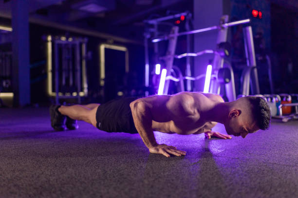 istock Dedicated man doing push-ups in the gym at night 2149816405