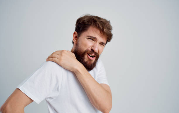 istock man touching shoulder with hand dislocation discomfort white t-shirt 2149816752