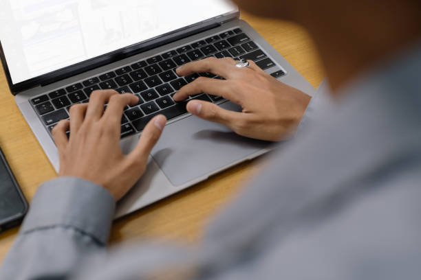 istock man seated at a desk with an open laptop in front of them 2149818464