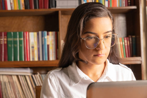 istock young Latina student, searching for information in a notebook, studying in a library 2149819219