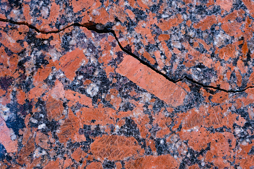 The cracked polished granite slab in the red, grey, white, and black mix.