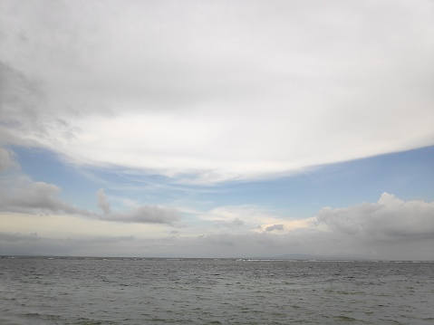 Big heavy white clouds above the sea during daytime