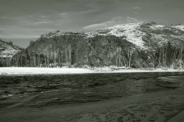 istock Snowcovered mountain landscape with a frozen river and cloudy sky. 2149823575