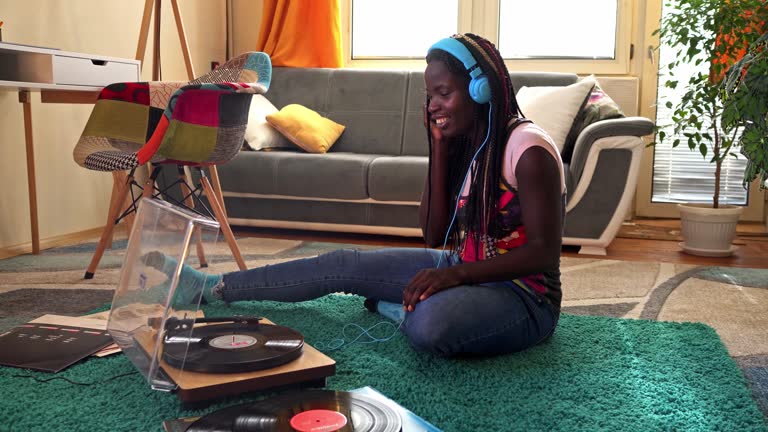 Young woman  listening to her favorite LP on an old record player.