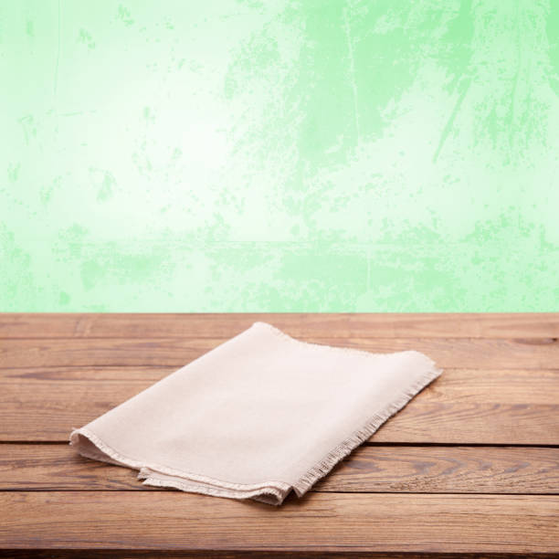 istock Empty tablecloth on wooden table with spring green background. Napkin close up top view mock up. Sophisticated Kitchen Aesthetic rustic chic background. 2149824322