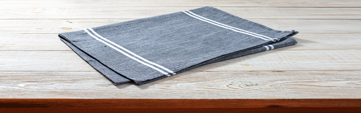 Empty tablecloth on wooden table with napkin top view mockup.