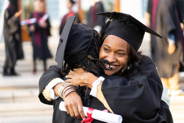 istock Two students celebrate receiving their diplomas with a hug 2149827150