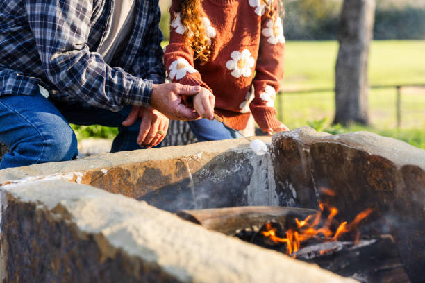 istock Low angle view grandfather teaching granddaughter how to roast marshmallow 2149828192