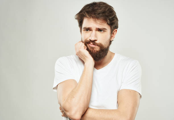 istock a man with a puzzled look looks to the side on a light background and a thick beard 2149829126