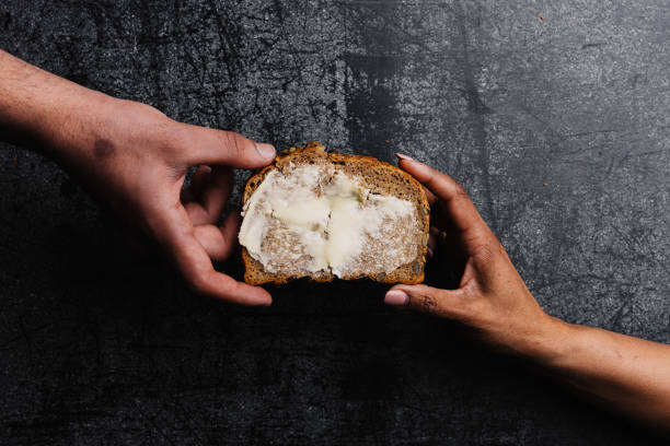 istock Farmhouse Bread Spread With Butter Held By Two Different People's Hands 2149829367