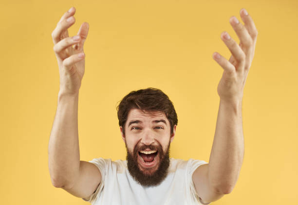 istock Energetic man raised his hands up and on a yellow background emotions model 2149830064