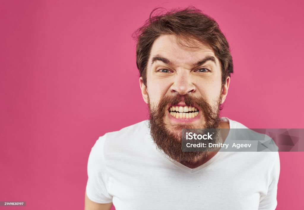 An Angry Man With A Bushy Beard Bared His Teeth Against A Pink Background Stock Photo Download