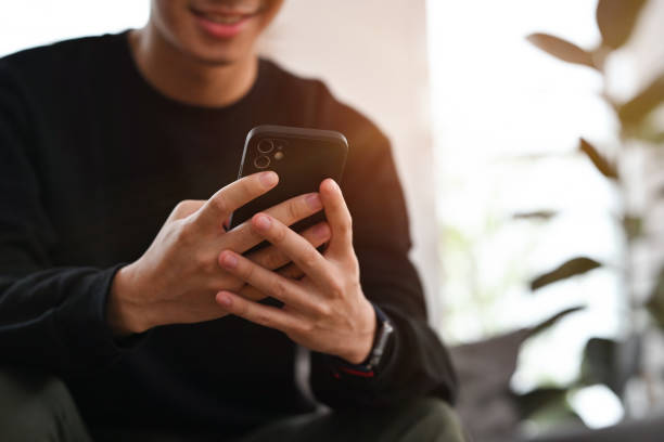 istock Smiling young asian man texting message, chatting friend on smart phone. People, technology and communication concept. 2149832217