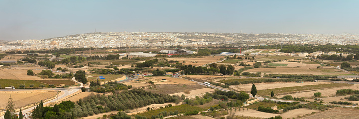 Panoramic view of a maltese landscape with agricultural fields. In the background is the town of Mosta.