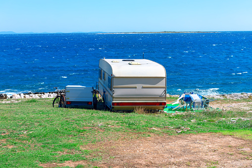 Caravan trailer on the beach in sunny summer day. Perfect summer coastal vacation