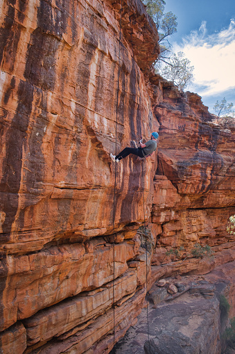 Rappelling down a sandstone rock face along the Z Bend River Trail to the gorge of the Murchison River, Kalbarri National Park, Western Australia
