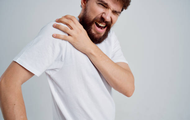 istock man touching shoulder with hand dislocation discomfort white t-shirt 2149839265