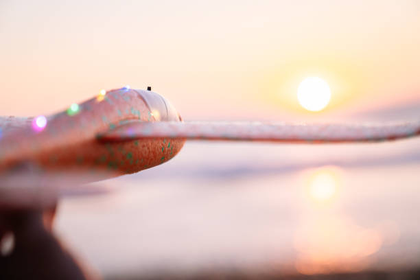 Close focus on a foam plane, sunset dreams blur.