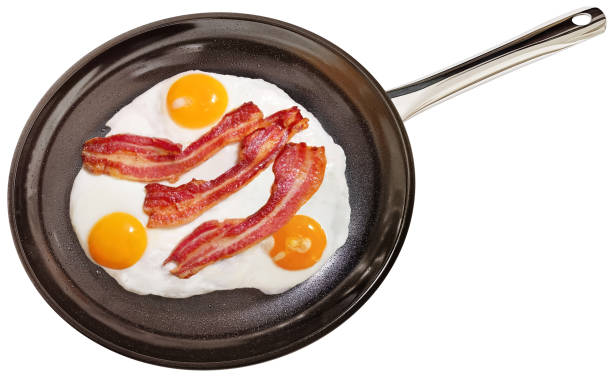istock Freshly Fried Crispy Crunchy Gourmet Bacon Rashers With Sunny Side Up Eggs In Large Black Non Slip Ceramic Coated Frying Pan Isolated On White Background High Resolution Stock Image 2149840116