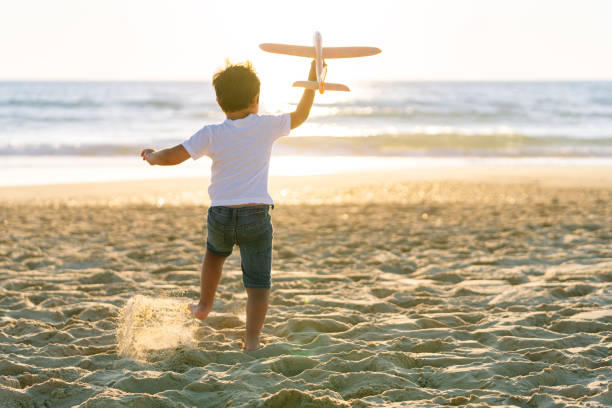 istock Child in Motion Playing with Airplane on Sunny Beach 2149840337