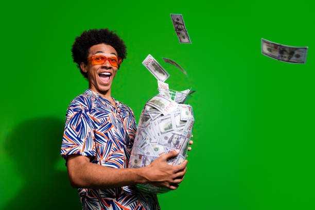 Photo of excited impressed man dressed print shirt dark glasses collecting cash glass jar empty space isolated green color background Photo of excited impressed man dressed print shirt dark glasses collecting cash glass jar empty space isolated green color background. millionnaire stock pictures, royalty-free photos & images