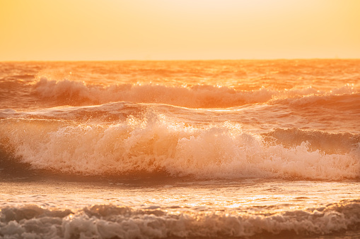 Sea water surface at sunset. Natural sunrise warm colors of ocean. Sea ocean water surface with foaming small waves at sunset. Evening sunlight sunshine above sea. Amazing landscape scenery. Nature background. Copy space.