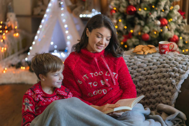 istock Woman reading a book to her son during Christmas day 2149842014