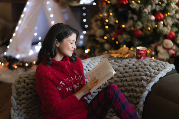istock Woman reading a book during Christmas night 2149842080