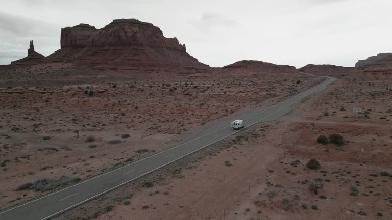 Camper truck driving in Monument Valley park, on Highway 163, Utah, USA. Aerial follow shot.