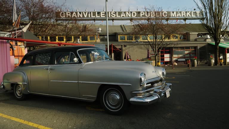 shot of a grey vintage car parked in Granville Island public Market  in Vancouver City on a cloudy day with a little bit of sun inBritish Columbia, Canada