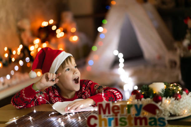 istock Surprised boy writing Christmas card 2149842432