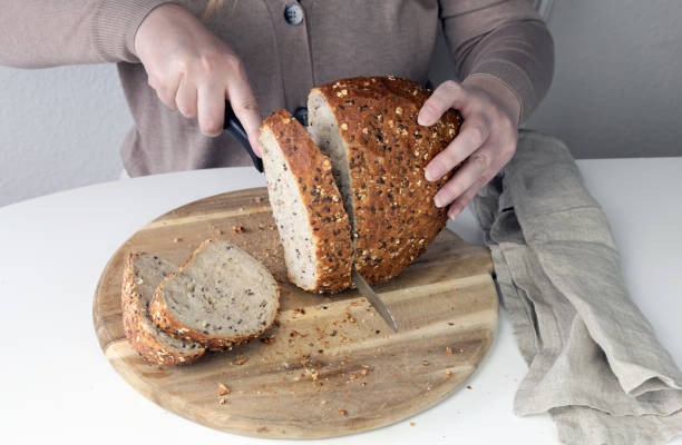 istock Woman cutting bread. 2149843042