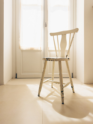 A bathroom bathed in soft day light with a wooden vintage stool