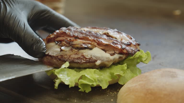 Placing restaurant quality grilled tasty gourmet burger on garnished bread bun