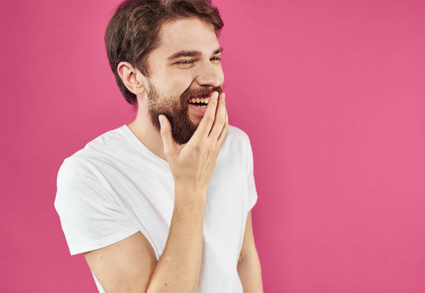 istock A cheerful guy with a beard laughs on a pink background and gestures with his hands 2149849308