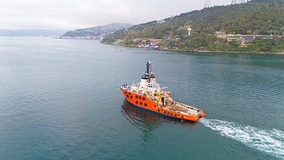 Aerial view of tugboat towing a nautical vessel in Istanbul Bosphorus.