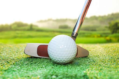 A putter is a golf club used on the putting green to hit the golf ball into the hole. The most important difference between different golf club shafts is the angle of the club face. or the angle between the surface of the wood and the vertical line. The background of the picture is a mountain landscape.