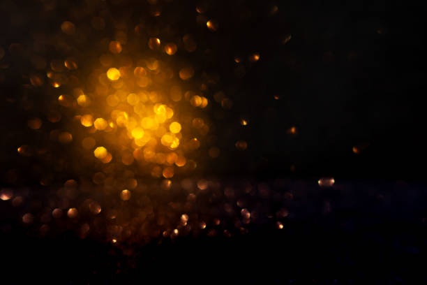 istock Warm golden bokeh lights illuminate a dark backdrop, creating an abstract pattern of soft glowing orbs ideal for backgrounds. Blurred shine bokeh for overlay effect. 2149851036