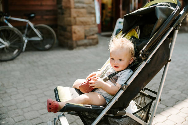 istock Adorable one year old boy sits in his stroller outside 2149853419