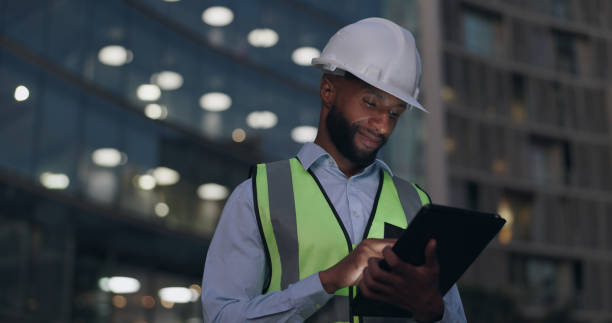 istock Black man, engineer and city building with tablet for online inspection or safety protocol, architecture or late night. Male person, hardhat and construction project with deadline, internet or urban 2149854074