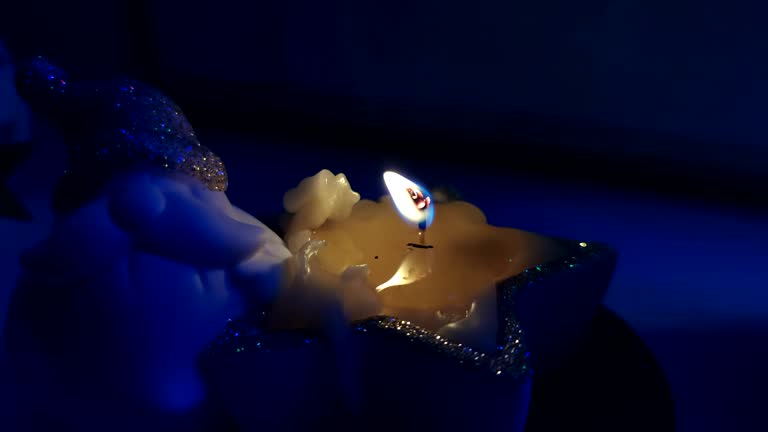 burning wax candle on windowsill at night