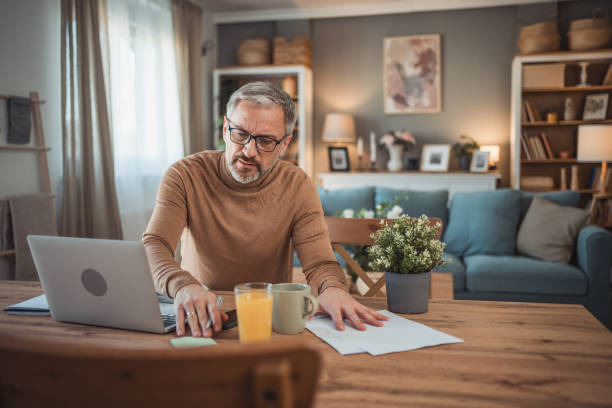 istock Middle aged man working from home office on laptop 2149855531